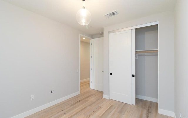 unfurnished bedroom featuring light wood-type flooring, visible vents, and baseboards