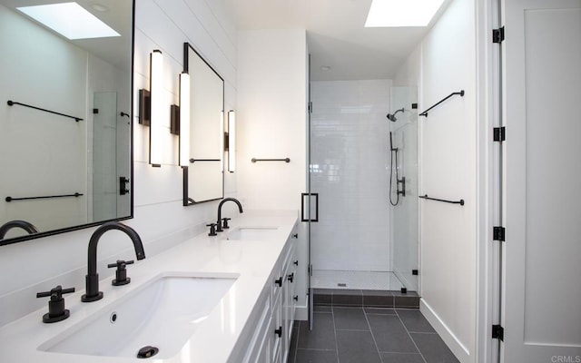 bathroom with tile patterned flooring, a sink, and a skylight