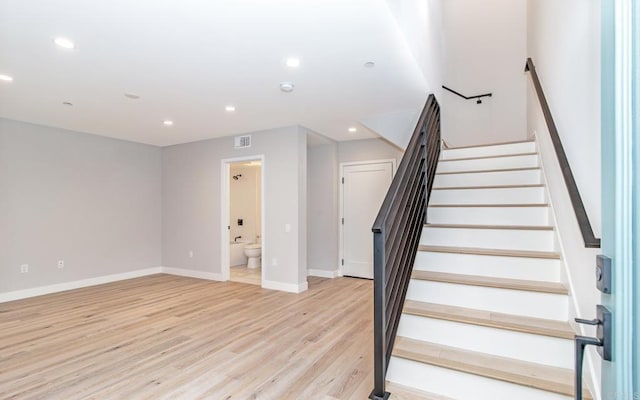 stairway featuring visible vents, wood finished floors, baseboards, and recessed lighting