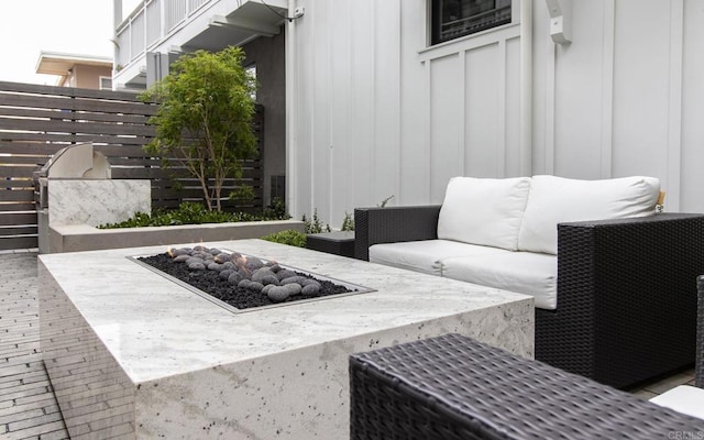 view of patio featuring an outdoor living space with a fire pit and fence