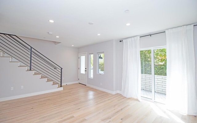 entrance foyer featuring stairs, a healthy amount of sunlight, recessed lighting, and wood finished floors
