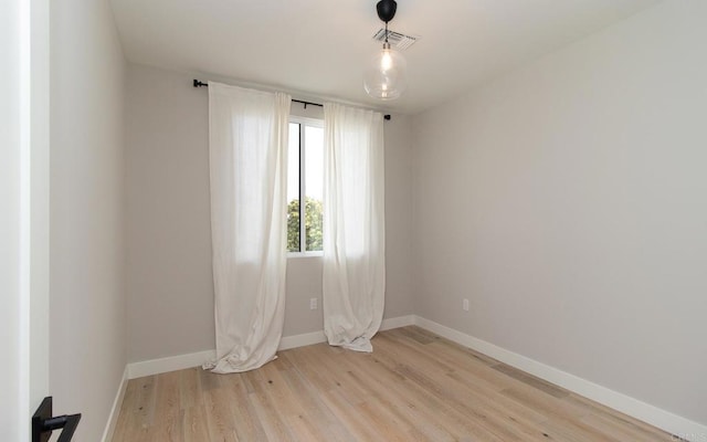 spare room with light wood-type flooring, baseboards, and visible vents