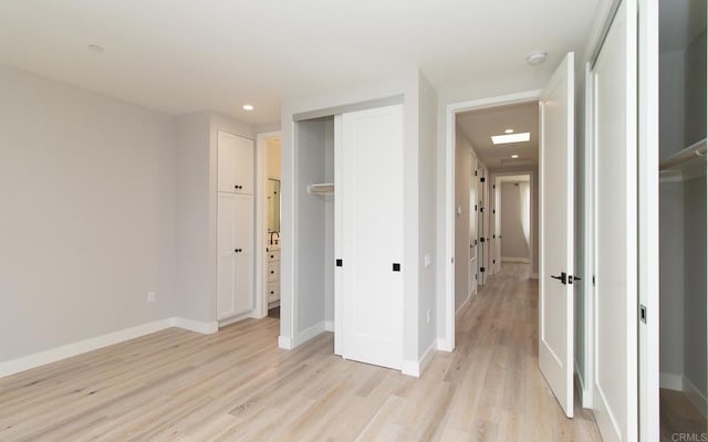 unfurnished bedroom with baseboards, light wood finished floors, and recessed lighting