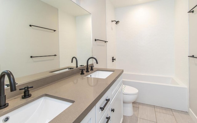 full bath featuring double vanity, toilet, bathtub / shower combination, and a sink