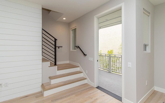 stairs featuring wood finished floors, baseboards, and recessed lighting
