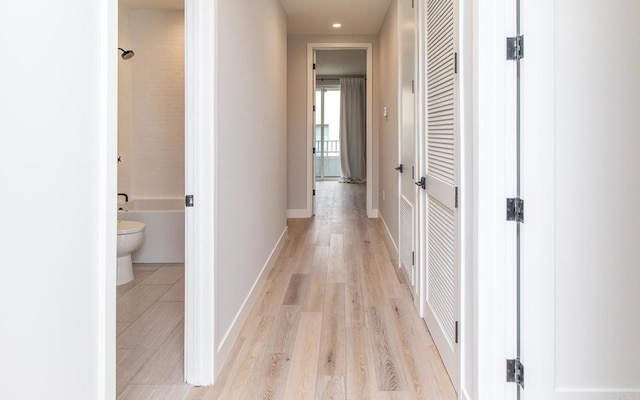 hall with light wood finished floors, baseboards, and recessed lighting