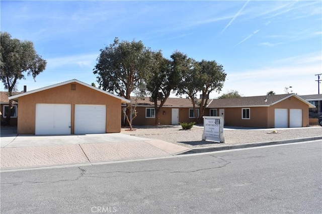 ranch-style house with an attached garage and stucco siding