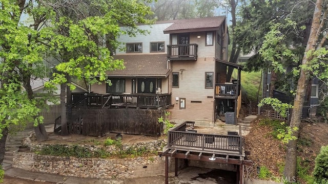 583 Arbula Dr, Crestline, CA 92325 - back of property with a balcony, a shingled roof, central air condition unit, and a wooden deck