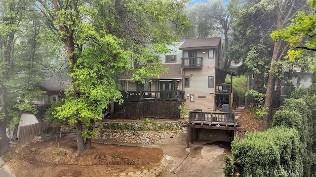 583 Arbula Dr, Crestline, CA 92325 - back of property featuring a shingled roof, a balcony, concrete driveway, a deck, and an attached garage