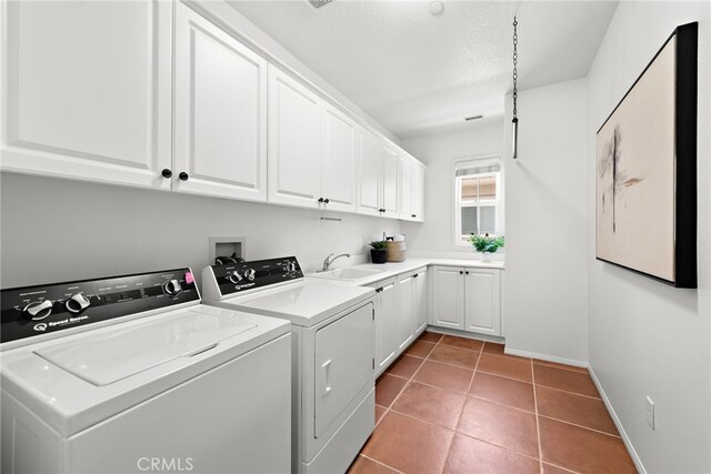 clothes washing area featuring cabinet space, washer and dryer, baseboards, and tile patterned floors