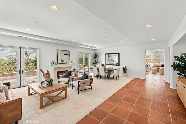 carpeted living room with tile patterned flooring, recessed lighting, and a lit fireplace
