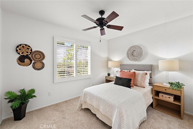 carpeted bedroom featuring baseboards and a ceiling fan