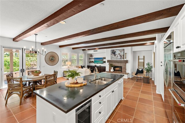 kitchen featuring a sink, a glass covered fireplace, dark countertops, wine cooler, and tile patterned flooring