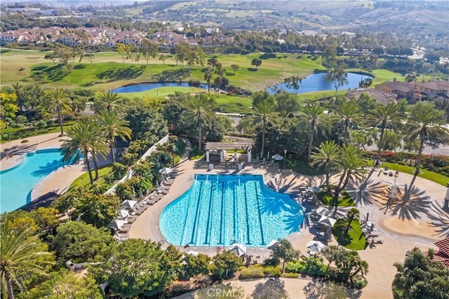 community pool with a water view, golf course view, and a patio area
