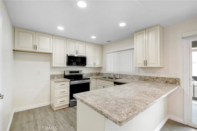 1023 S Citron St Unit 21, Anaheim, CA 92805 - kitchen with stainless steel electric range, light countertops, a peninsula, light wood-style floors, and recessed lighting
