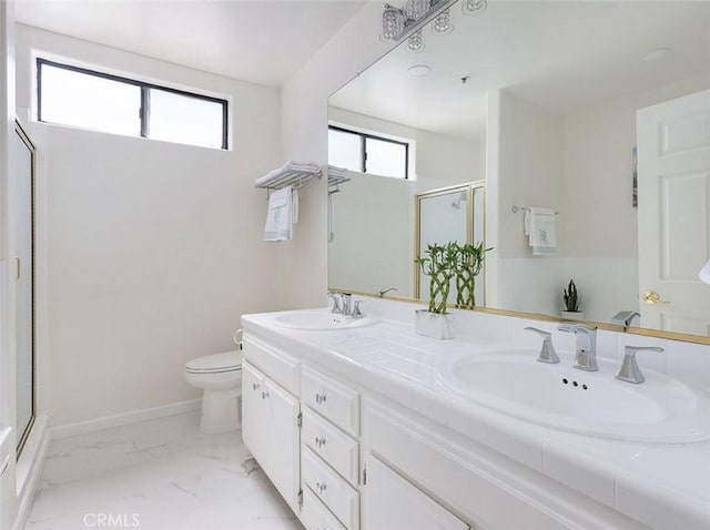 bathroom with a stall shower, healthy amount of natural light, toilet, and double vanity