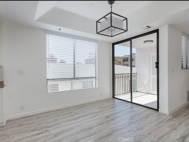 unfurnished dining area featuring light wood-type flooring and baseboards