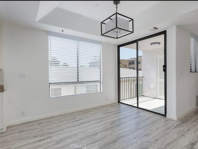 unfurnished dining area featuring light wood-style flooring and baseboards
