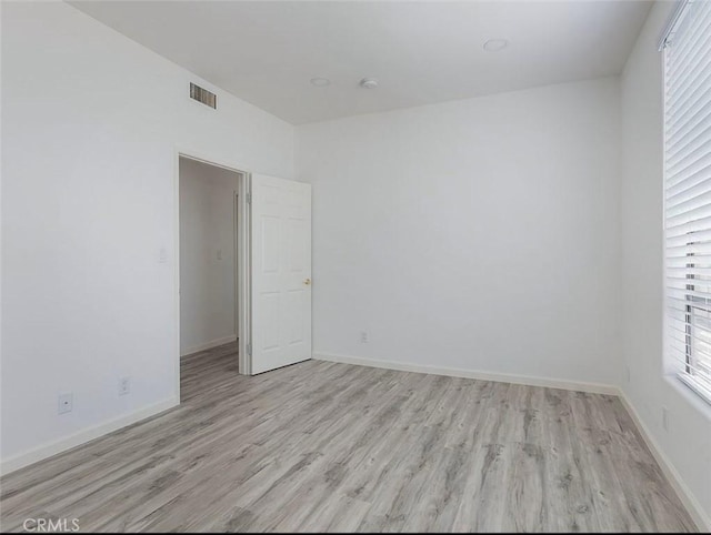 empty room with light wood-type flooring and baseboards
