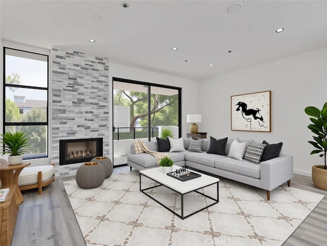 living area featuring wood finished floors, recessed lighting, and a tile fireplace