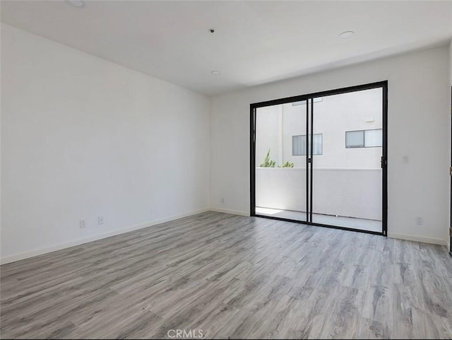 unfurnished room with light wood-style flooring and baseboards