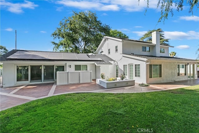 2141 Westminster Dr, Riverside, CA 92506 - back of property with roof mounted solar panels, a patio area, stucco siding, and a chimney