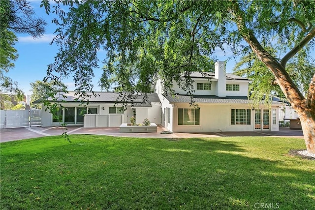 2141 Westminster Dr, Riverside, CA 92506 - back of property with french doors, stucco siding, a patio, a chimney, and roof mounted solar panels