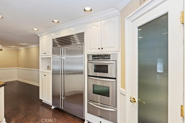2141 Westminster Dr, Riverside, CA 92506 - kitchen with stainless steel appliances, a warming drawer, crown molding, white cabinets, and dark wood finished floors