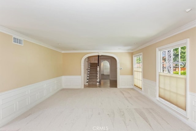 2141 Westminster Dr, Riverside, CA 92506 - empty room with a decorative wall, arched walkways, wainscoting, light carpet, and crown molding