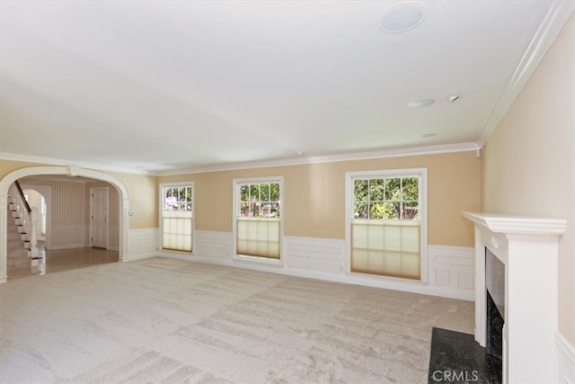 2141 Westminster Dr, Riverside, CA 92506 - unfurnished living room featuring carpet, arched walkways, ornamental molding, a wainscoted wall, and a decorative wall