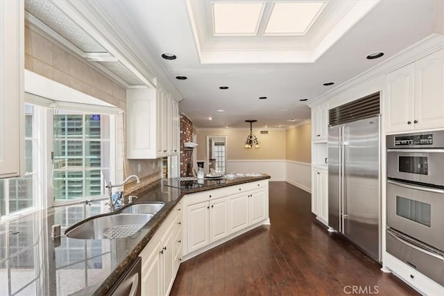 2141 Westminster Dr, Riverside, CA 92506 - kitchen with stainless steel appliances, a warming drawer, a sink, white cabinetry, and a peninsula