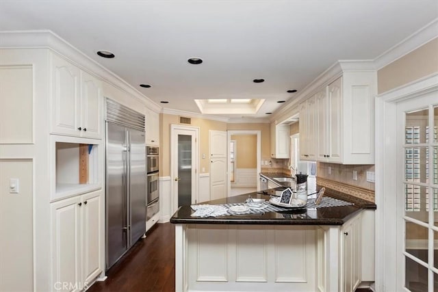 2141 Westminster Dr, Riverside, CA 92506 - kitchen with a peninsula, a warming drawer, white cabinets, dark wood-type flooring, and crown molding