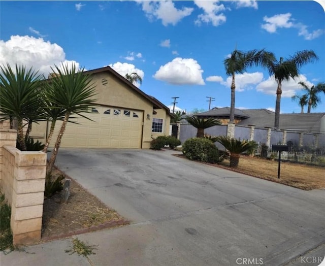 725 18th Pl, Delano, CA 93215 - ranch-style house featuring driveway, stucco siding, an attached garage, and fence
