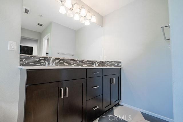 24189 Darmera Dr, Lake Elsinore, CA 92532 - full bath with backsplash, baseboards, double vanity, and tile patterned flooring