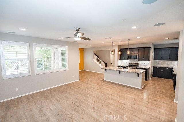 24189 Darmera Dr, Lake Elsinore, CA 92532 - kitchen featuring stainless steel microwave, range, a breakfast bar area, a sink, and a ceiling fan