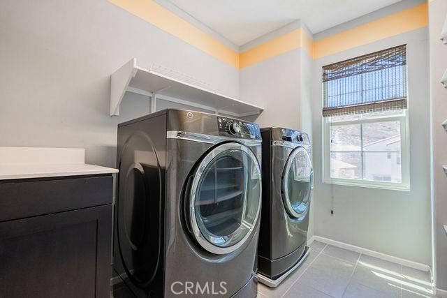 24189 Darmera Dr, Lake Elsinore, CA 92532 - clothes washing area with washer and dryer, light tile patterned flooring, and baseboards