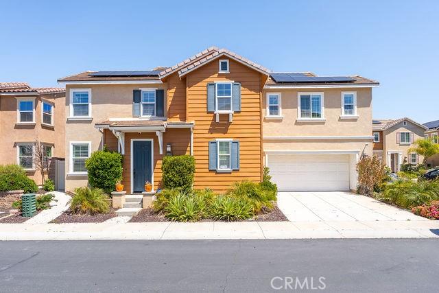 24189 Darmera Dr, Lake Elsinore, CA 92532 - traditional-style house with a garage, driveway, solar panels, and stucco siding