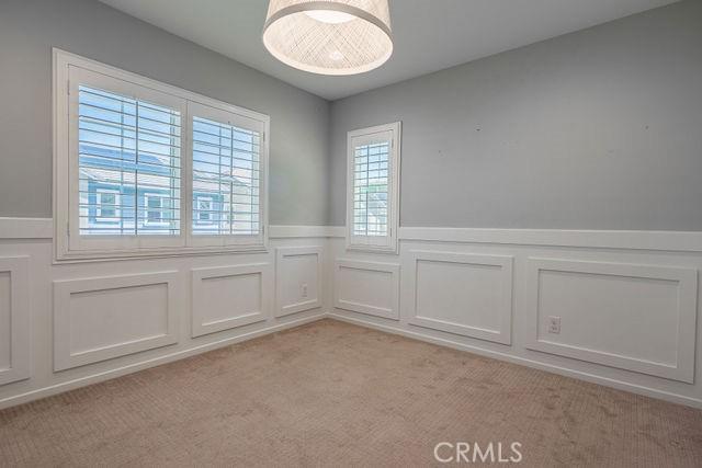 24189 Darmera Dr, Lake Elsinore, CA 92532 - spare room featuring light carpet, a wainscoted wall, and a decorative wall