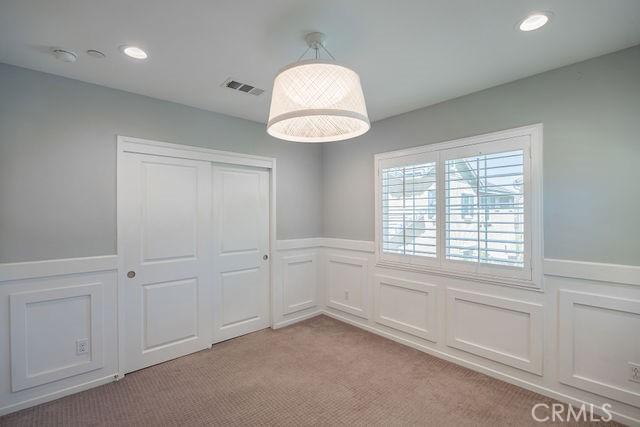 24189 Darmera Dr, Lake Elsinore, CA 92532 - unfurnished dining area with a decorative wall, a wainscoted wall, light colored carpet, and recessed lighting