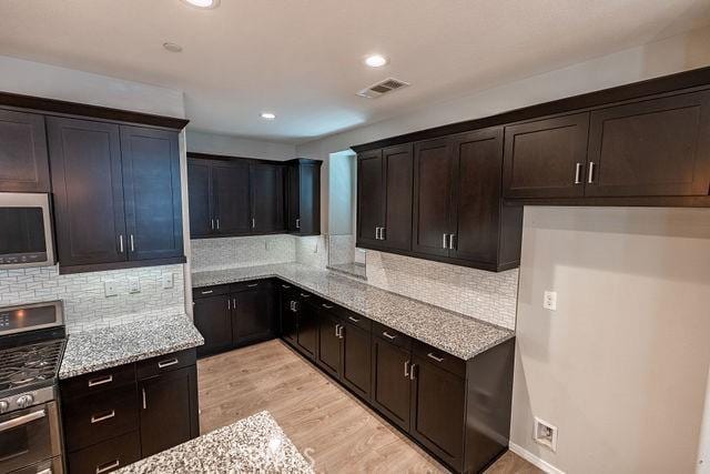 24189 Darmera Dr, Lake Elsinore, CA 92532 - kitchen with stainless steel appliances, light stone countertops, decorative backsplash, light wood finished floors, and recessed lighting