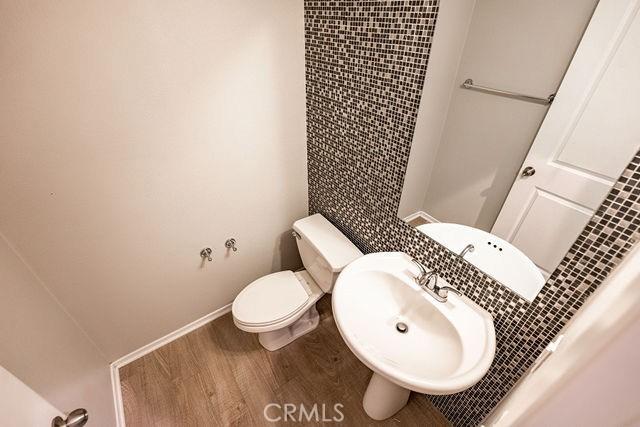 24189 Darmera Dr, Lake Elsinore, CA 92532 - bathroom featuring wood finished floors, a sink, toilet, and baseboards