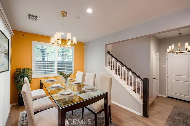 24189 Darmera Dr, Lake Elsinore, CA 92532 - dining area featuring a chandelier, wood finished floors, baseboards, stairway, and recessed lighting