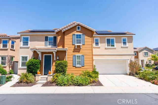 24189 Darmera Dr, Lake Elsinore, CA 92532 - traditional home featuring a garage, concrete driveway, solar panels, stucco siding, and a tiled roof