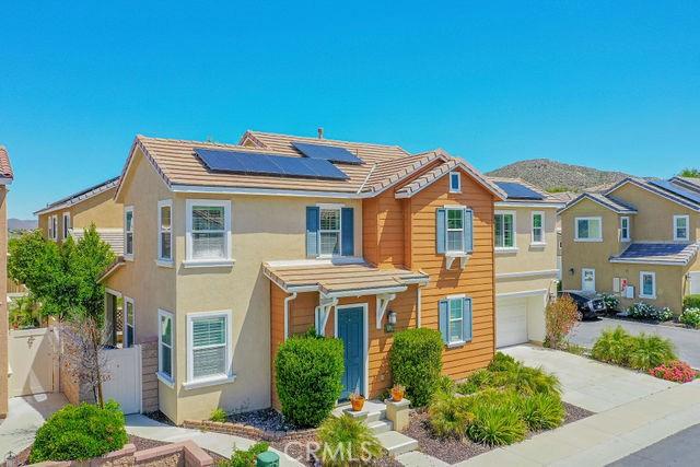 24189 Darmera Dr, Lake Elsinore, CA 92532 - traditional-style house featuring solar panels, fence, stucco siding, a garage, and concrete driveway