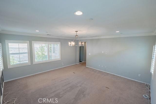 24189 Darmera Dr, Lake Elsinore, CA 92532 - spare room featuring a chandelier, ornamental molding, light colored carpet, baseboards, and recessed lighting