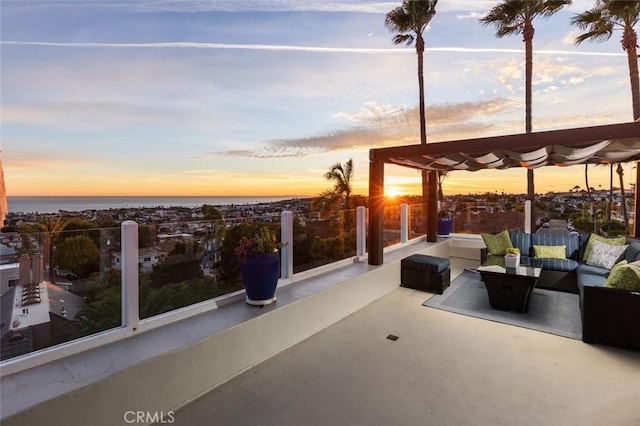 patio terrace at dusk with an outdoor hangout area and a water view