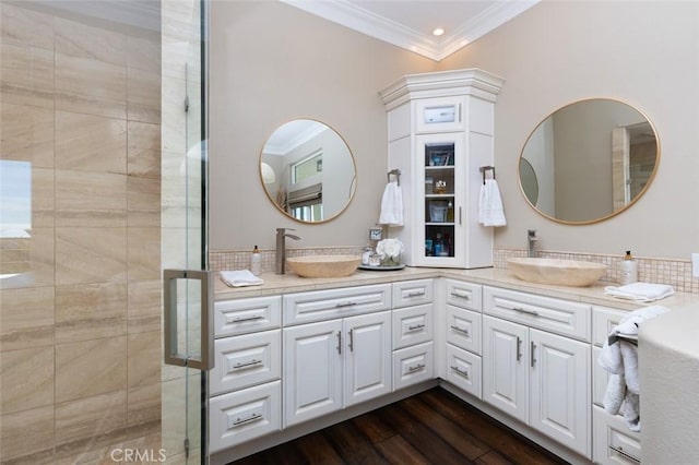 full bath with wood finished floors, a shower stall, ornamental molding, and a sink