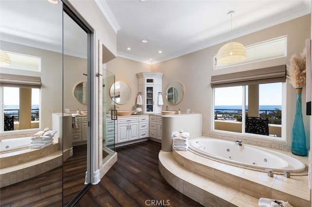 bathroom featuring a jetted tub, a stall shower, wood finished floors, crown molding, and vanity