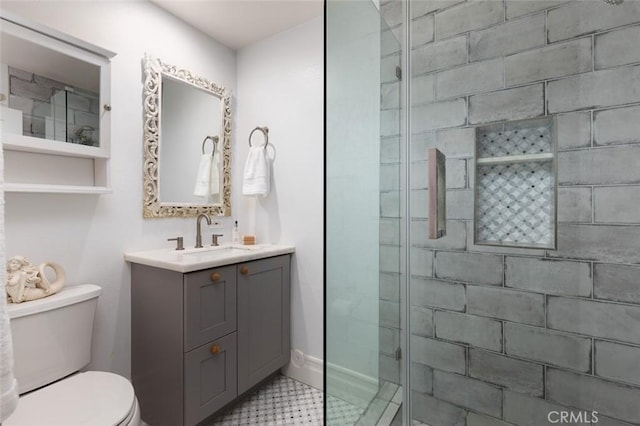 bathroom with a shower stall, vanity, and toilet