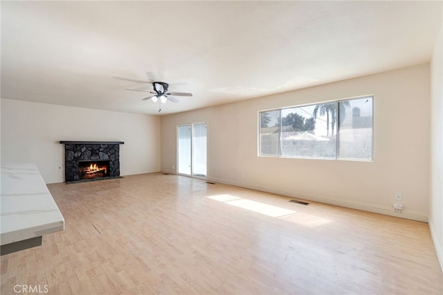 2738 S Fairway Ct, Visalia, CA 93277 - unfurnished living room with light wood finished floors, a ceiling fan, a fireplace, visible vents, and baseboards